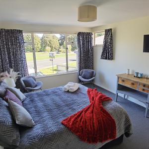 Un dormitorio con una cama grande y una ventana en Kea by the Lake en Te Anau