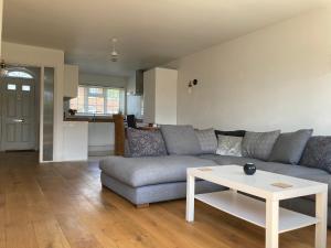a living room with a couch and a table at Pristine 3 Bed Home For Family or Business Stays, Great Location, FREE Parking, Park Views, Sleeps 5! in Ashford