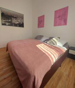 uma cama num quarto com duas fotografias na parede em Ferienwohnung Waldliebe em Homburg