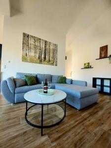 ein Wohnzimmer mit einem Sofa und einem Tisch in der Unterkunft Ferienwohnung Waldliebe in Homburg