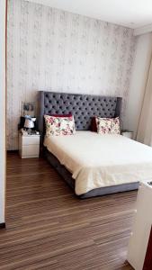 a bedroom with a large bed with a gray headboard at Tamares in Casablanca