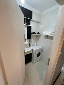 een kleine witte badkamer met een wasmachine bij 1Brr in Taksim in Istanbul