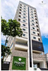 um edifício branco alto com um cartaz em Apartamento aconchegante no centro de São Lourenço em São Lourenço