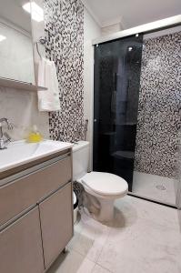 a bathroom with a toilet and a sink and a shower at Apartamento Top, 3 quartos, Wi-Fi 300 Mbps in Porto Alegre