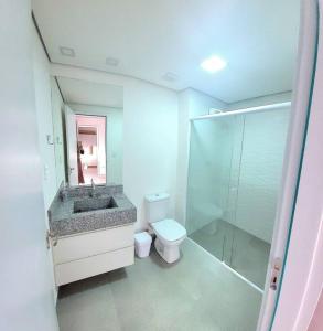 y baño con lavabo, aseo y ducha. en Apartamento aconchegante no centro de São Lourenço en São Lourenço