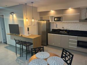 a kitchen with a table and chairs and a counter at Apartamento aconchegante no centro de São Lourenço in São Lourenço