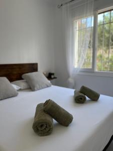 duas toalhas sentadas em cima de uma cama branca em CAN GALERETES em Denia