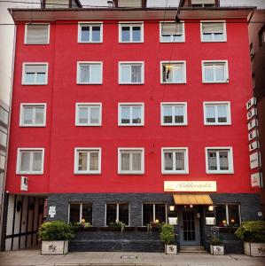 a red building with white windows at Hotel-Restaurant Köhler in Stuttgart