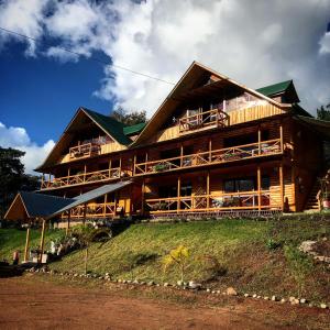 una gran casa de madera en la cima de una colina en Treff Lodge Hotel, en Oxapampa