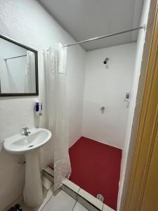 ein weißes Badezimmer mit einem Waschbecken und einem Spiegel in der Unterkunft Cabinas Golfito in Golfito