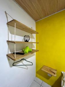 a room with yellow walls and wooden shelves at Cabinas Golfito in Golfito