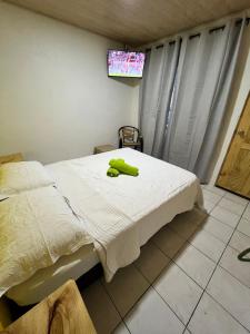 ein Schlafzimmer mit einem Bett mit einem grünen Handtuch darauf in der Unterkunft Cabinas Golfito in Golfito