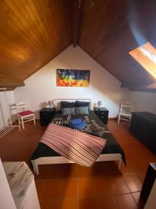 sypialnia z dużym łóżkiem na poddaszu w obiekcie Buganvilla Alentejo w mieście São Francisco da Serra