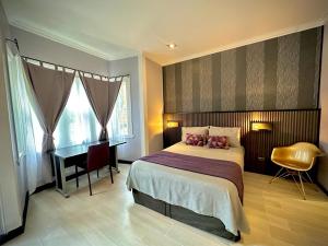 a bedroom with a bed and a desk and a bed sidx sidx sidx at La Blanca Hotel in Viña del Mar