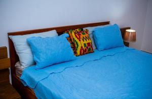 a bed with blue sheets and blue pillows at Luxor garden apartments Accra Ghana in Accra
