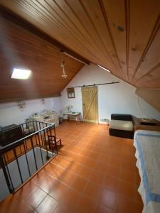 Habitación en el ático con cama y sofá en Buganvilla Alentejo en São Francisco da Serra