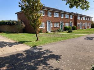 a brick building with a tree in front of it at Pristine 3 Bed Home For Family or Business Stays, Great Location, FREE Parking, Park Views, Sleeps 5! in Ashford