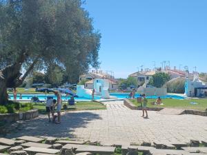 een groep mensen die bij een zwembad staan bij Pedras D` EL Rei Village in Tavira