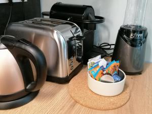 Una encimera de cocina con una tostadora y una taza de comida. en WelkHome Inn Best Suites - Spa, en Troyes