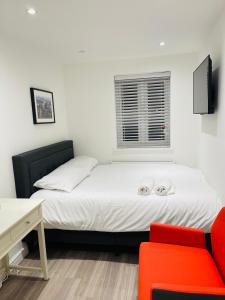 a bedroom with a bed and a red chair at Riverside En suite Double Room E14 in London