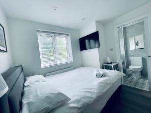 a bedroom with a large bed and a toilet at Riverside En suite Double Room E14 in London