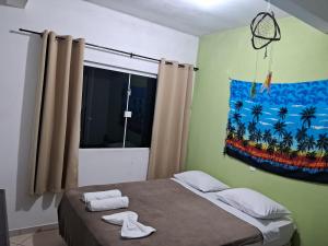 a bedroom with a bed and a painting on the wall at Pousada Encantadas in Pontal do Paraná