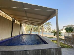 a swimming pool under a canopy in a house at شالية كوف COV FIlLA in Al Khobar