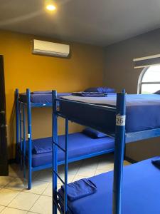 a room with two bunk beds and a fan at Alajuela Backpackers Airport Hostel in Alajuela City