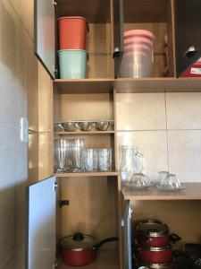 a kitchen with some bowls and glasses on shelves at Casa aconchegante em Catas Altas in Catas Altas