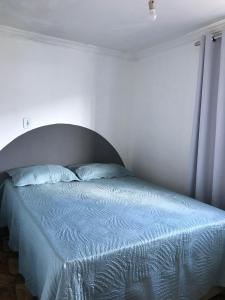 a bedroom with a bed with a blue bedspread at Casa aconchegante em Catas Altas in Catas Altas