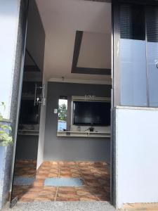 a hallway with a mirror and a television on a wall at Casa aconchegante em Catas Altas in Catas Altas