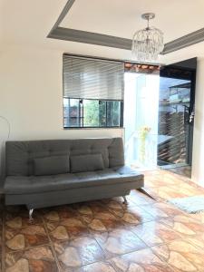 a couch in a living room with a chandelier at Casa aconchegante em Catas Altas in Catas Altas