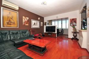 a living room with a green leather couch and a table at Apartments Ruzarija in Trogir