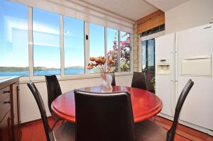 a dining room with a table and chairs and windows at Apartments Ruzarija in Trogir +33 photos
