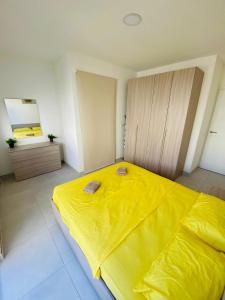 una camera con un grande letto giallo di Amnesia Apartment a San Pawl il-Baħar