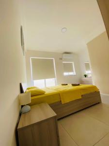 una camera da letto con un grande letto con lenzuola gialle di Amnesia Apartment a San Pawl il-Baħar
