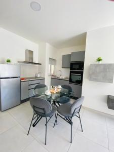 una cucina con tavolo in vetro e sedie in camera di Amnesia Apartment a San Pawl il-Baħar
