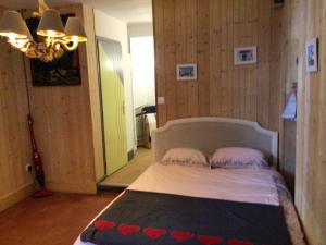 a bedroom with a bed with a black and red blanket at La cabine le Courlis in Le Tréport