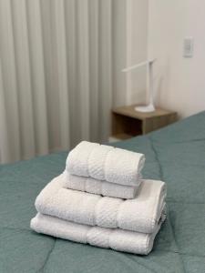 a stack of towels sitting on top of a bed at Luxury Apartments in Mendoza