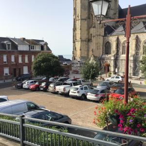a parking lot with cars parked in front of a church at La cabine le Courlis in Le Tréport +6 photos