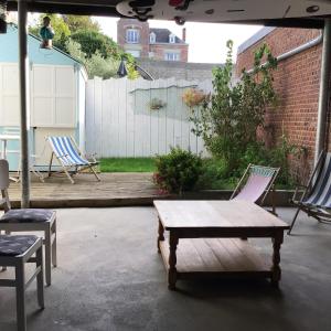a patio with two chairs and a table and a bench at La cabine le Courlis in Le Tréport