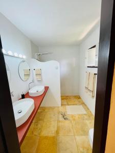a bathroom with two sinks and a red counter at Kitesurf Oasis Maracajaú in Maracajaú