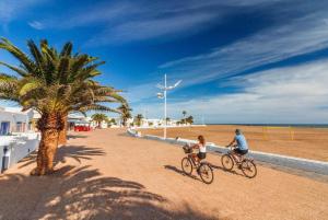 a man and a child riding bikes on the beach at O sole mio en Playa honda in Playa Honda