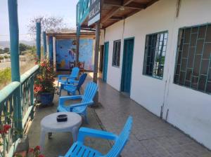 eine Gruppe blauer Stühle auf einer Veranda in der Unterkunft Guest House Villa Machalilla in Machalilla