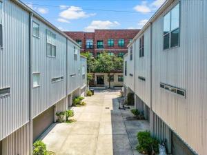 un vicolo tra due edifici con un edificio sullo sfondo di Luxe 3 Story Townhome with Downtown View Near NRG Stadium Centrally Located Walkable To Popular Restaurants sleeps 8 a Houston