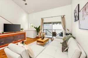 un soggiorno con un divano bianco e una TV di Luxe 3 Story Townhome with Downtown View Near NRG Stadium Centrally Located Walkable To Popular Restaurants sleeps 8 a Houston