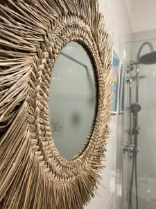 a large wicker mirror on a wall in a bathroom at 10 MAGGIO APARTMENTS in Augusta