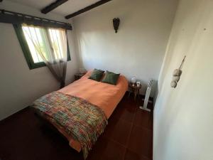 1 dormitorio con 1 cama en una habitación con ventana en La Casita de La Esperanza en La Esperanza