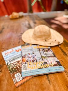 una revista y un sombrero de paja en una mesa de madera en Woodstock Palmresort Curaçao, en Willemstad