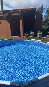 a large blue swimming pool in front of a house at La Casita de La Esperanza in La Esperanza